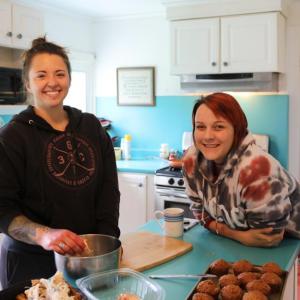 Photo-Sarah Sawyer (in black) and Alyssa Carey cooking together in the recovery house kitchen. (Photo courtesy Dara Hurt)