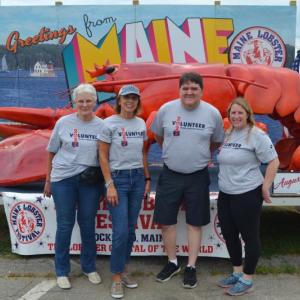 A group of volunteers from UMA Rockland Center pose with Rocky the lobster at the 2022 Maine Lobster Festival. (Photo courtesy Maine Lobster Festival)