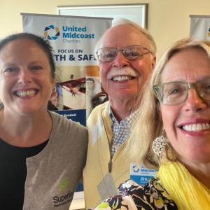 Nicole Gogan, Finding Our Voices board treasurer and owner of Superior Restoration, and Patrisha McLean, the group’s founder and president with Jim Hengerer, United Midcoast Charities vice chair and grants committee chair. (Photo courtesy Finding Our Voices)