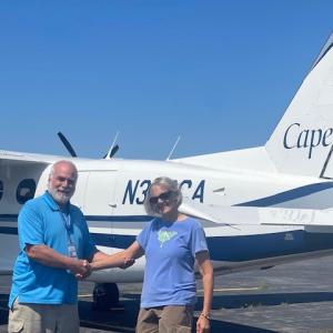 Cape Air Station Manager Rocky Stenger receives a congratulatory handshake from Knox County Commissioner Dorothy Meriwether. (Photo courtesy of Knox County Airport).