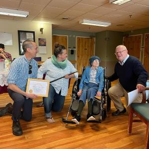Presenting the Boston Post Cane. From left, Select Board Members Josh Gerritsen and Ladleah Dunn, Peg Miller, and Town Administrator David Kinney. (Photo by Diane O’Brien)