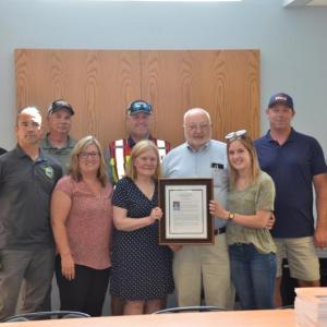 Allen Mitchell is surrounded by fellow firefighters and family. From left: Charlie Pearson, Brandon Allen, Todd Philbrook, Fire Chief Jason Peasley, Daughter Jill Mitchell, Wife Marge Mitchell, Granddaughter Alison Saucier, John Wickenden and Bill Lane. (Photo by Lynda Clancy)