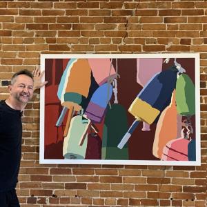 Alan Claude stands alongside one of his prints called "Lobster Buoys." (Photo courtesy Rockport Public Library)
