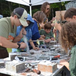Children enthusiastically make use of stone-cutting tools at an artisan table set up by the Maine Stone Guild. (Photos by Lynda Clancy)