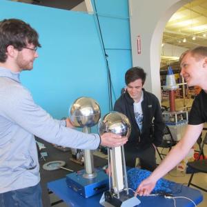University of Maine undergrad students in the College of Engineering & Physics Program demonstrate how an electrostatic generator conducts “hair raising” static electricity. Photo by Kay Stephens