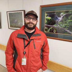 Photographer Alex Evans stands with some of the work featured in his first art exhibit, on display at Waldo County General Hospital through August 5. (Photo courtesy Waldo County General Hospital)