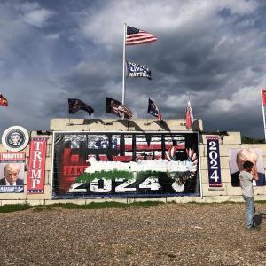 In Waldoboro, Anthony Lash (left) talks with neighbors about the recent vandalization of the large monument to President Trump. Sometime during the final week of May, the banner stating TRUMP 2024 was painted with an image which appears to be similar to the Palestinian Flag. (Sarah Masters photo)