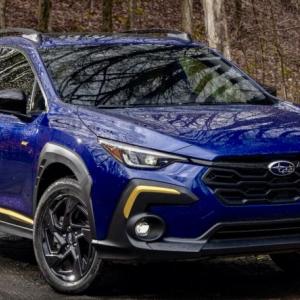 With both rear seatbacks folded down, the re-designed 2024 Crosstrek offers up to 54.7 cubic feet of useful space plus a tailgate opening that’s 41 inches across. The Sport model gets raised roof rails. (Think kayaks, paddleboards, skis.) This color is Sapphire Blue Pearl; note the hot-gold highlights and the Sport trim’s 18-inch Dark Gray Alloy wheels.