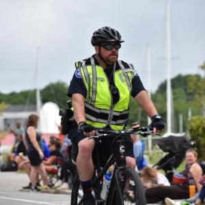 Rockland Police Officer John Bagley rides a bicycle during the 2023 Lobster Festival Parade. (Photo by Sarah Thompson)