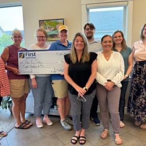 West Bay Rotarians and First National Bank staff celebrate The First’s sponsorship of the 2024 Duck Derby and upcoming Christmas tree sales events. From left to right are WBR’s Barbara Heard, Lisa Dresser, Club Secretary Kate Dullea, Club President Shelly Butler; First National Bank’s Niki Janczura, Jacob Clement, Chelsea Hatchey, Amanda Fisher, and Ashley Simmons.
