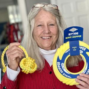 Eliza Massey with dog toys from The Maine Dog for the “Into the Light!” pet gift basket that can be won with an uploaded selfie in the event’s raffle. Loyal Biscuit contributed $100 worth of yellow cat and dog toys and snacks to the pet gift basket. (Photo by Patrisha McLean)