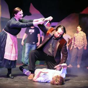 Meredith (Maggie Machaiek) urges Dr. Parker (Andrew Lipman) to show compassion to Bat Boy (Miles Mailloux, supine) despite the townspeople's (background, l-r: Dakota Wing, Malaya Moore, Ada Curry, Katey Stearns) pleas to kill him. (Photo courtesy Belfast Maskers)