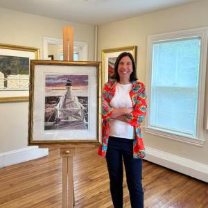Barbara Prey at Barbara Prey Projects gallery with the Marshall Point Light print Dusk's Early Light that survived the Port Clyde fire at the General Store. (Photo courtesy Barbara Prey)
