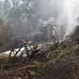 Firefighters let hoses spray into the rear foundation of a former barn. (Photo by Sarah Thompson)