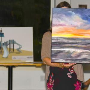 Pictured here at Belfast Rotary Club’s Evening by the Bay gala and auction, the event that launched the 17th annual Belfast Harbor Fest on Aug. 17, are a rendering of the club’s $200,000 centennial playground Legacy Project (left), to be built at City Park in Belfast in 2025, and “Glow,” an original oil painting by Jerri Finch which went to the high bidder at the live auction.