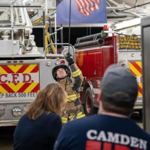 Firefighter Dylan Cautela hoists hose. (Photo by Tim 