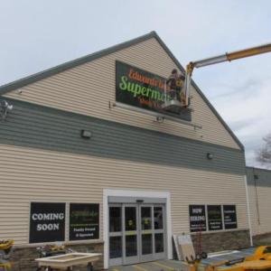 Last touches on the sign for the new Edwards Brothers Supermarket in Searsport. Photo by Kay Stephens