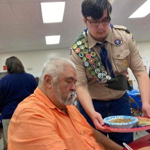 At the Veteran's Appreciation Beef Stew Dinner put on by the Warren Historical Society, veteran Danny Swindler is served lunch by his grandson Star Scout Logan Bailey, who is a member of Troop 254 Warren. (Photo courtesy Chuck Mahaleris)