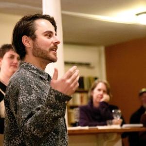 Artistic Director Tucker Atwood (front) announces the 2025 Belfast Maskers' season at an annual meeting of volunteers. (back, l-r: Angelina Nichols, Andrea Butler, Mike Nickerson, Julia Olson. (Photo by Gwyneth Sauvage.)