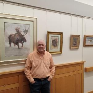 Artist Peter Giustra stands with some of his works, now on display at MaineHealth Pen Bay Hospital. (Photo courtesy MaineHealth)