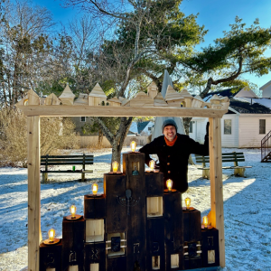 Aaron Margolis and his Menorah in 2024, cedar, copper, found materials. (Photo courtesy Parsonage Gallery)