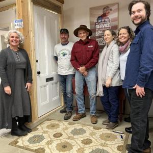 Midcoast Habitat for Humanity staff and volunteers stand in front of the memorial door honoring former President Jimmy Carter’s work with Habitat for Humanity. (L-R) Tia Anderson, Todd Look, Bob Newbest, Kristie Kosalski, Maggi Blue, and Dashiell Marley. (Photo courtesy Midcoast Habitat for Humanity)