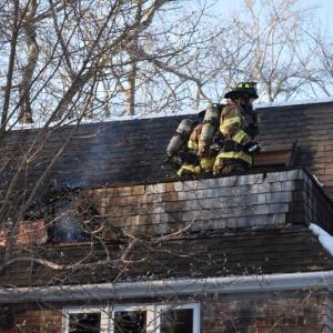 Camden firefighters cut and saturate around a chimney pipe at 201 Chestnut Street, in Camden, Feb. 11, 2025. (Photo by Sarah Thompson)