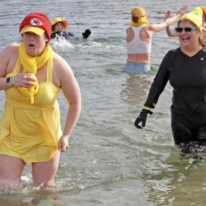Nicole Larrabee in yellow bathing suit is a Finding Our Voices board member, and Mary Kamradt right behind her is the nonprofit’s chief of staff. They were two of dozens wading into frigid water at Rockport Harbor with Wicked Nippy Dippahs. (Photo by Jane Kurko)