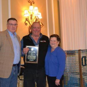 DMR Commissioner Patrick Keliher (left) presents the 2025 DMR Andy Mays Award of Excellence to John and Judy Williams of Stonington. (Photo courtesy Department of Marine Resources)