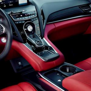 For 2025, the RDX cabin has been upgraded with more leather and Ultrasuede, a roomier bin in the console, easier access to the phone charging pad and more ambient lighting. The knob in the center is the drive mode selector; beneath that lie the P-R-N-D buttons, with a second setting on the Drive button for S, Sport. And below them is the computer touchpad. 