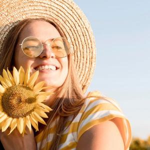 girl holding sunflower in sunlight