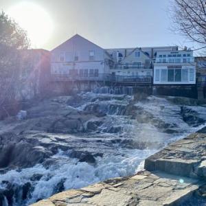 The Montgomery Dam sits at the outflow of the Megunticook River, sending water hurtling underneath the Camden Deli and out into the harbor below. Years into contentious deliberations about what to do with the ailing structure, the town still hasn’t decided whether to remove the dam or maintain it. Photo by Stephanie McFeeters. camden dam