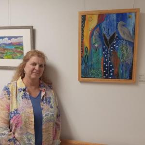 Artist Camilla Jewett stands with some of her works, now on display at MaineHealth Waldo Hospital. (Photo courtesy MaineHealth Waldo Hospital)