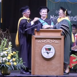 Kate Braestrup receives an honorary degree from Husson University at its May 10 commencement. c