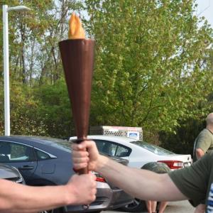Arthur Smith, of the Knox County Sheriff's Office, and Max King, of the Rockland Police Dept., try to help this photographer snap a close up of two hands holding the torch. Perhaps we'll try again next year.(Photo by Sarah Thompson)