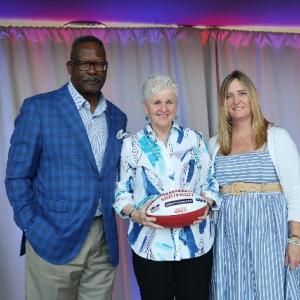 Patriots Pro Football Hall of Famer Andre Tippett (far left) and Gillette’s VP of Communications & Community Affairs, Global Grooming, Kara Buckley congratulate Maureen Keeley from The Center for Grieving Children for being selected as a 2025 Myra Kraft Community MVP Award winner. During the June 3 luncheon, the Kraft family, the Patriots Foundation and Gillette awarded $275,000 in grants to 26 New England nonprofits. The Center for Grieving Children received a $10,000 grant in honor of Maureen’s volunteer 