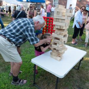 LCHA volunteer Dan Watts assists a youngster with a Jenga tower at last year's "Jailhouse Rock!" event. (Photo courtesy Lincoln County Historical Association)
