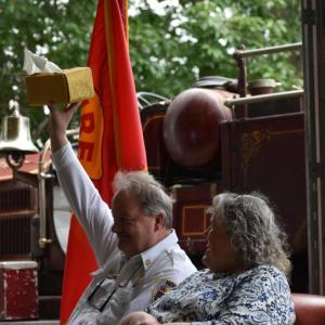 Retiring Hope Fire Chief Clarence Keller raises the gift that emcee Camden Fire Chief Chris Farley thought was an appropriate "Chiefly" gift for Keller. (Photo by Sarah Thompson)