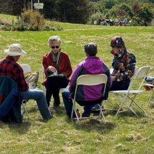 a group sits in an open field.