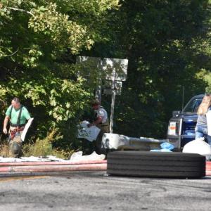 In the foreground, tires blown from their axles. In the background, fire crews lay chemical absorbency pads to soak up some of the diesel. (Photo by Sarah Thompson)