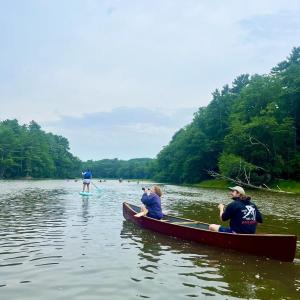 Canoe and paddle boarders row down a river. (Photo courtesy Maeve Cosgrove)