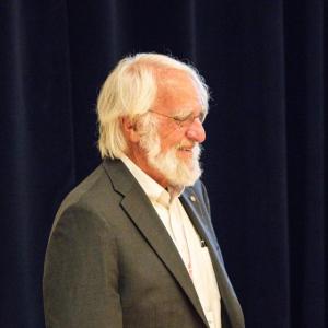 Man in front of dark curtain