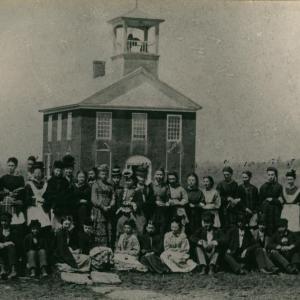 Black and white photo of students in front of a school