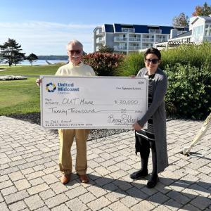 Man and woman pose with gigantic check