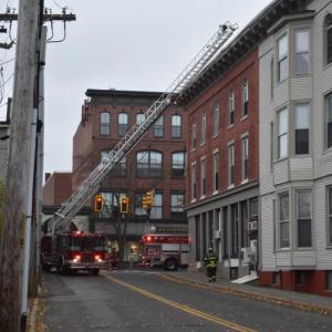 Ladder truck raised into position to reach the roof of a building
