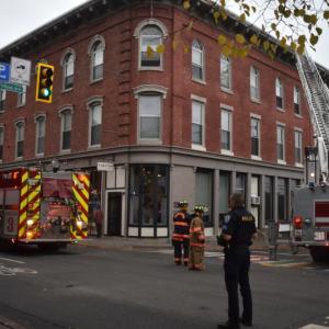 Corner of a building at an intersection with fire trucks on both visible sides