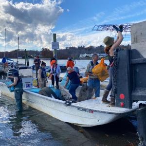 Volunteers unload trash from boats at the Damariscotta town landing following a successful cleanup in 2024. (Photo courtesy Coastal Rivers Conservation Trust)