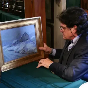 (Photo courtesy MaineHealth) Man appraises painting