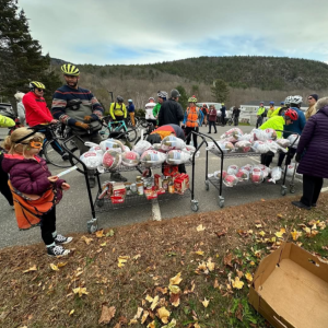 (Photo courtesy Maine Sport Outfitters) Bicyclers stand around carts filled with frozen turkeys