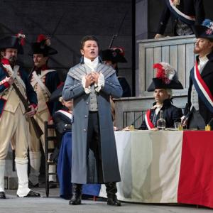 Male sings while soldiers stand in background